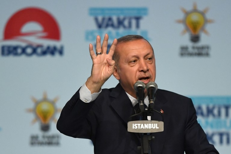 Turkish President Recep Tayyip Erdogan flashes four finger sign (rabia sign) on May 29, 2018 in Istanbul during an electoral meeting presenting candidates for the upcoming parliamentary elections. 
Turkey will hold snap parliamentary and presidential elections on June 24. / AFP PHOTO / OZAN KOSE