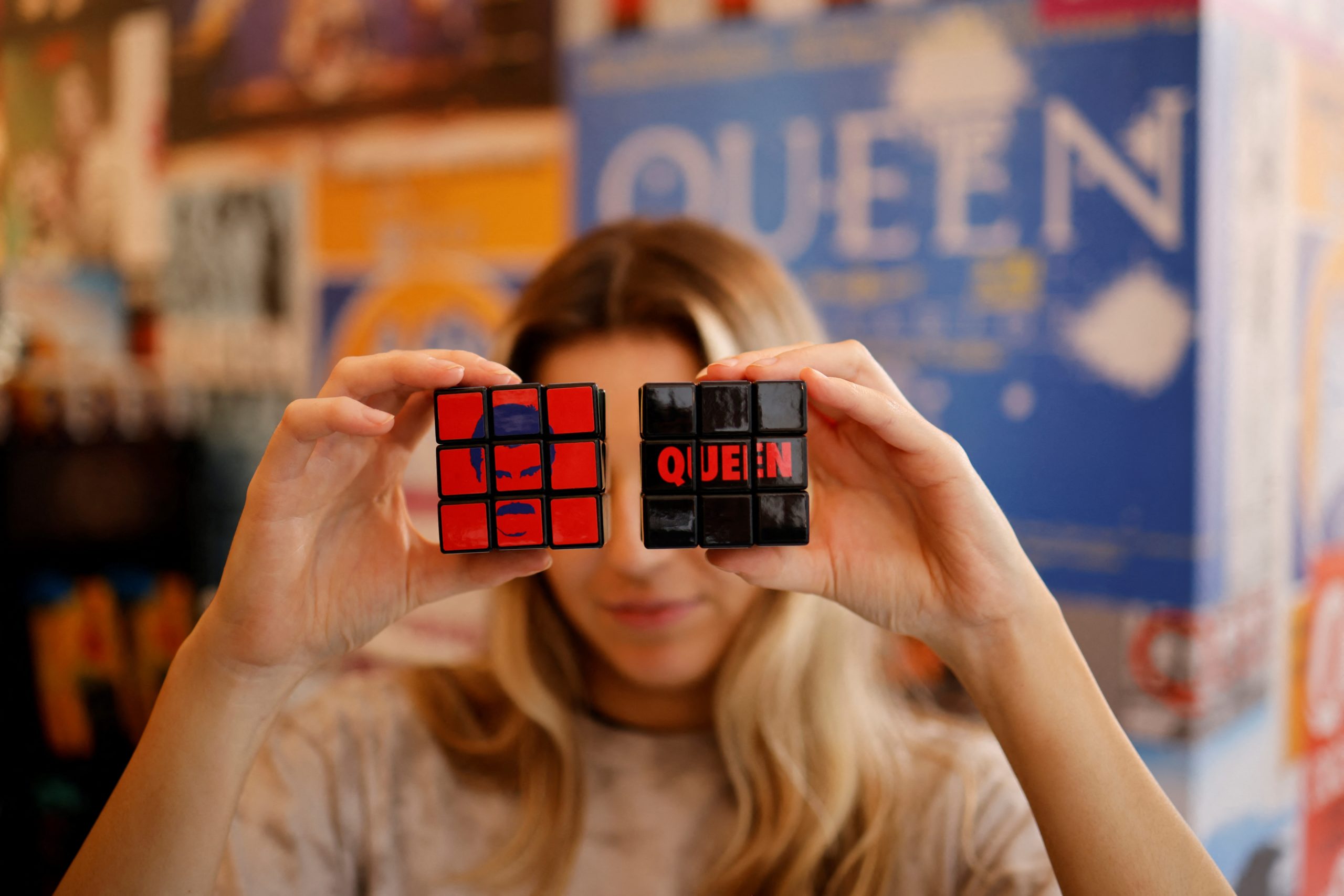 A shop assistant poses with official merchandise of legendary British rock group Queen on sale at their newly opened store in central London on September 27, 2021. (Photo by Tolga Akmen / AFP)