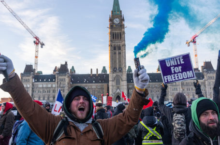 OTTAWA, ON – JANUARY 29: A man sets off a smoke firework during a rally against COVID-19 vaccine mandates on Parliament Hill on January 29, 2022 in Ottawa, Canada. Thousands turned up over the weekend to rally in support of truckers using their vehicles to block access to Parliament Hill, most of the downtown area Ottawa, and the Alberta border in hopes of pressuring the government to roll back COVID-19 public health regulations.   Alex Kent/Getty Images/AFP (Photo by Alex Kent / GETTY IMAGES NORTH AMERICA / Getty Images via AFP)