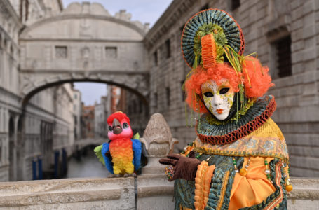A masked reveller wearing a traditional carnival costume poses on St Mark Square, Venice on February 20, 2022, during the annual carnival. (Photo by ANDREA PATTARO / AFP)