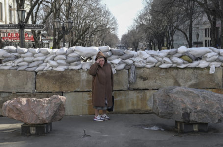 A resident stands next to a sandbag barricade in Odessa on March 13, 2022. (Photo by BULENT KILIC / AFP)