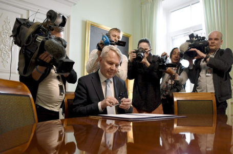 Finnish Foreign Minister Pekka Haavisto (C) signs a petition for NATO membership in front of members of the media in Helsinki on May 17, 2022. – Finland and Sweden will submit their bids to join NATO together on May 17 at the military alliance’s headquarters in Brussels, Swedish Prime Minister Magdalena Andersson said. (Photo by Antti Aimo-Koivisto / Lehtikuva / AFP) / Finland OUT