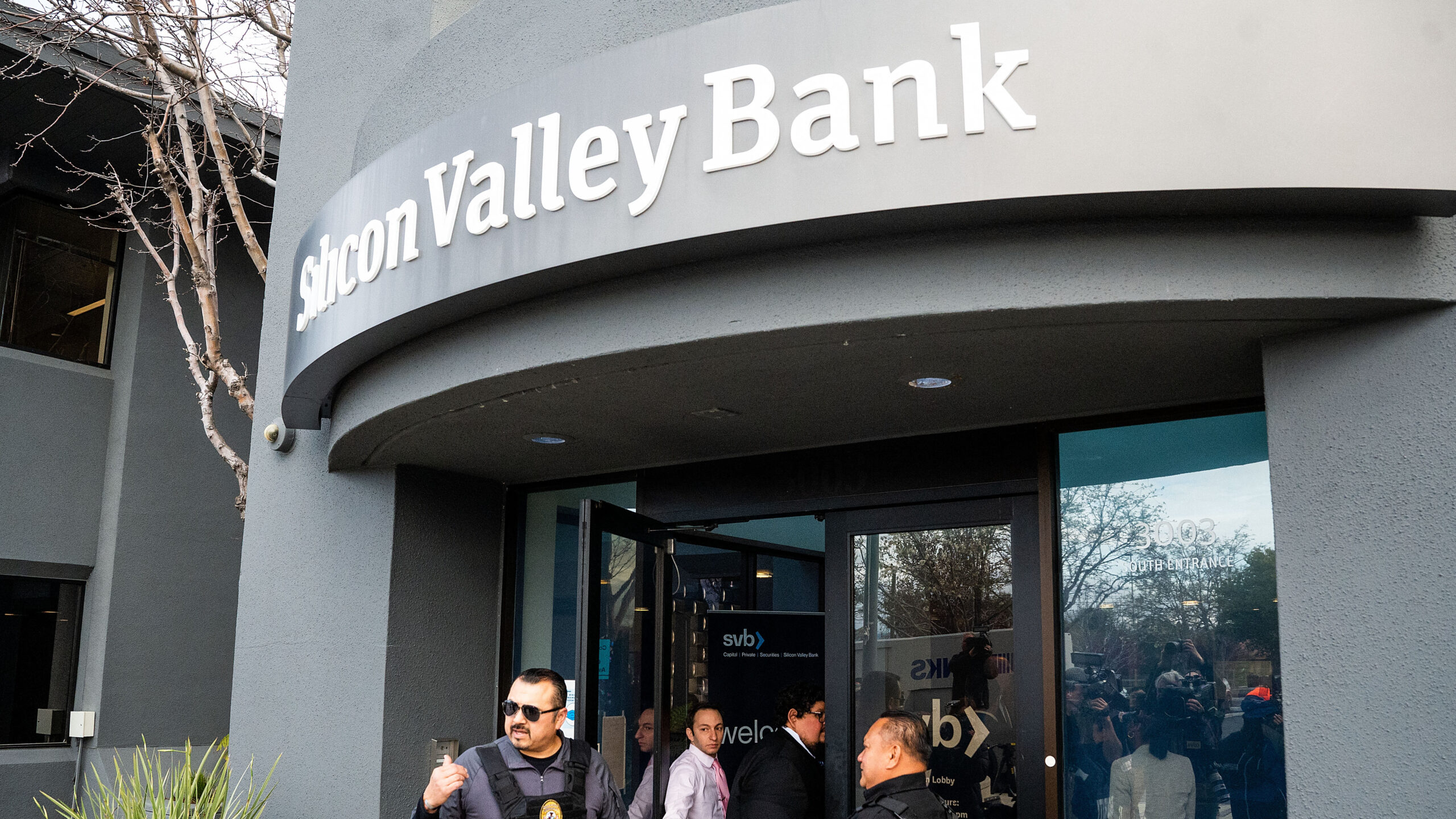 Security guards and FDIC representatives open a Silicon Valley Bank (SVB) branch for customers at SVBs headquarters in Santa Clara, California, on March 13, 2023. – US President Biden sought to reassure Americans over the country’s banking system on Monday, while insisting emergency measures would not be paid for by taxpayers, as additional banks came under stress following the collapse of Silicon Valley Bank last week, the second largest bank failure in history, and New York regulators took control of Signature Bank on Sunday. (Photo by NOAH BERGER / AFP)