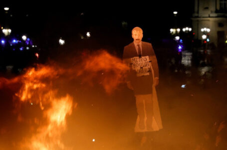 An effigy of French President Emmanuel Macron is help up near a fire during a demonstration on Place de la Concorde in Paris on March 17, 2023, the day after the French government pushed a pensions reform using the article 49.3 of the constitution. – French President’s government on March 17, 2023 faced no-confidence motions in parliament and intensified protests after imposing a contentious pension reform without a vote in the lower house. Across France, fresh protests erupted in the latest show of popular opposition to the bill since mid-January. (Photo by Geoffroy VAN DER HASSELT / AFP)