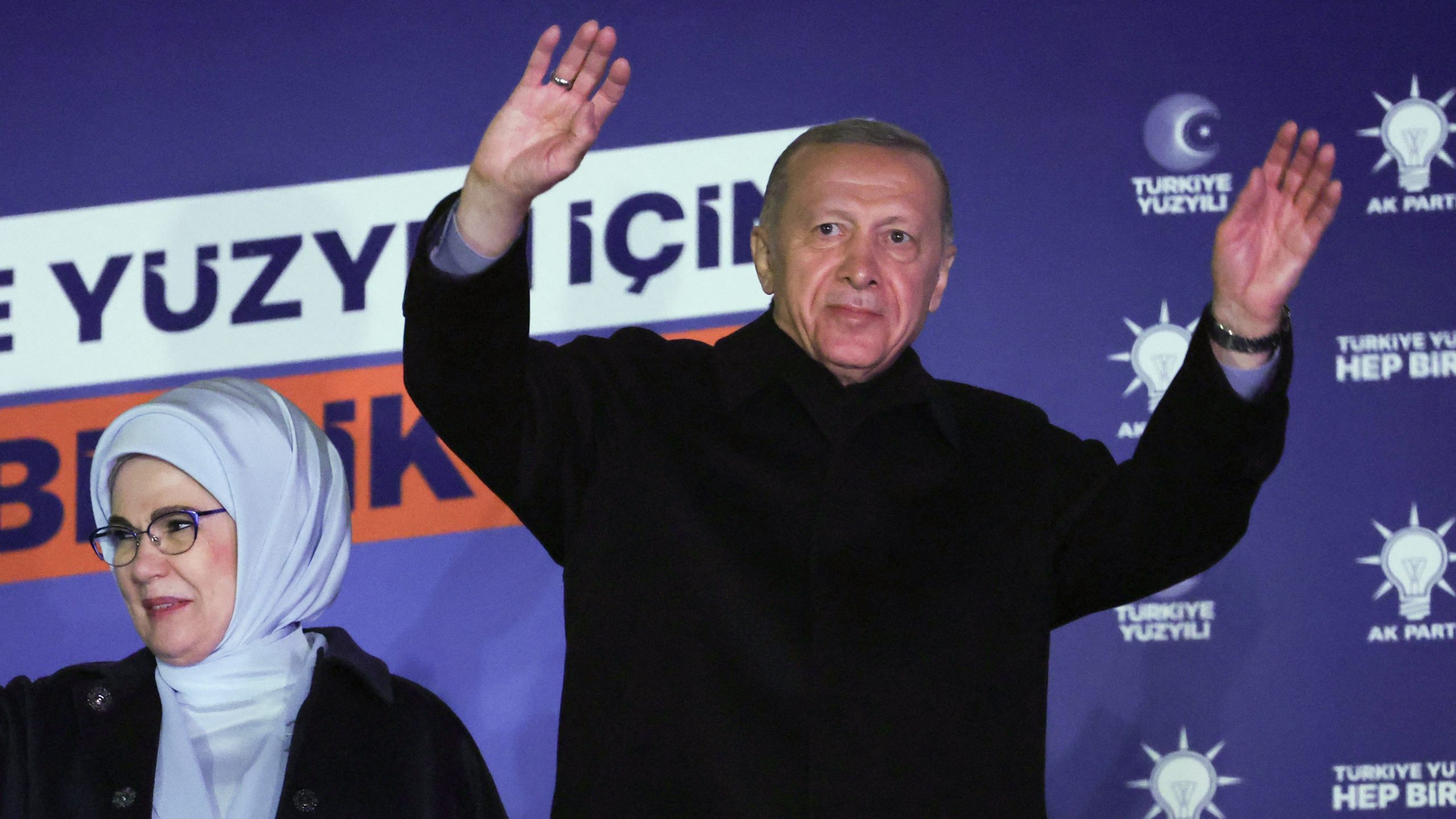 Turkish President Tayyip Erdogan (R), accompanied by his wife Ermine Erdogan (L), waves to supporters at the AK Party headquarters in Ankara, Turkey May 15, 2023. Turkey is braced for its first election runoff after a night of high drama showed President Recep Tayyip Erdogan edging ahead of his secular rival but failing to secure a first-round win. (Photo by Adem ALTAN / AFP)