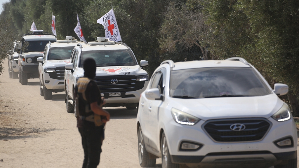 Un militante de las Brigadas Qassam observa desde un costado de la carretera cómo vehículos del Comité Internacional de la Cruz Roja (CICR) parten con el segundo grupo de rehenes israelíes liberados por Hamás. Foto: AFP
