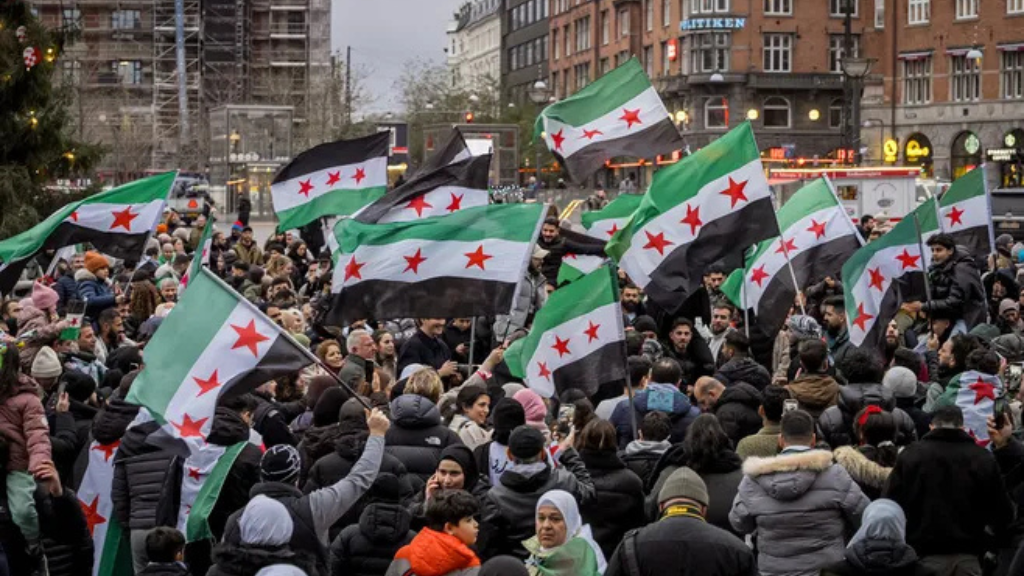 Manifestación de la población siria alzando sus banderas